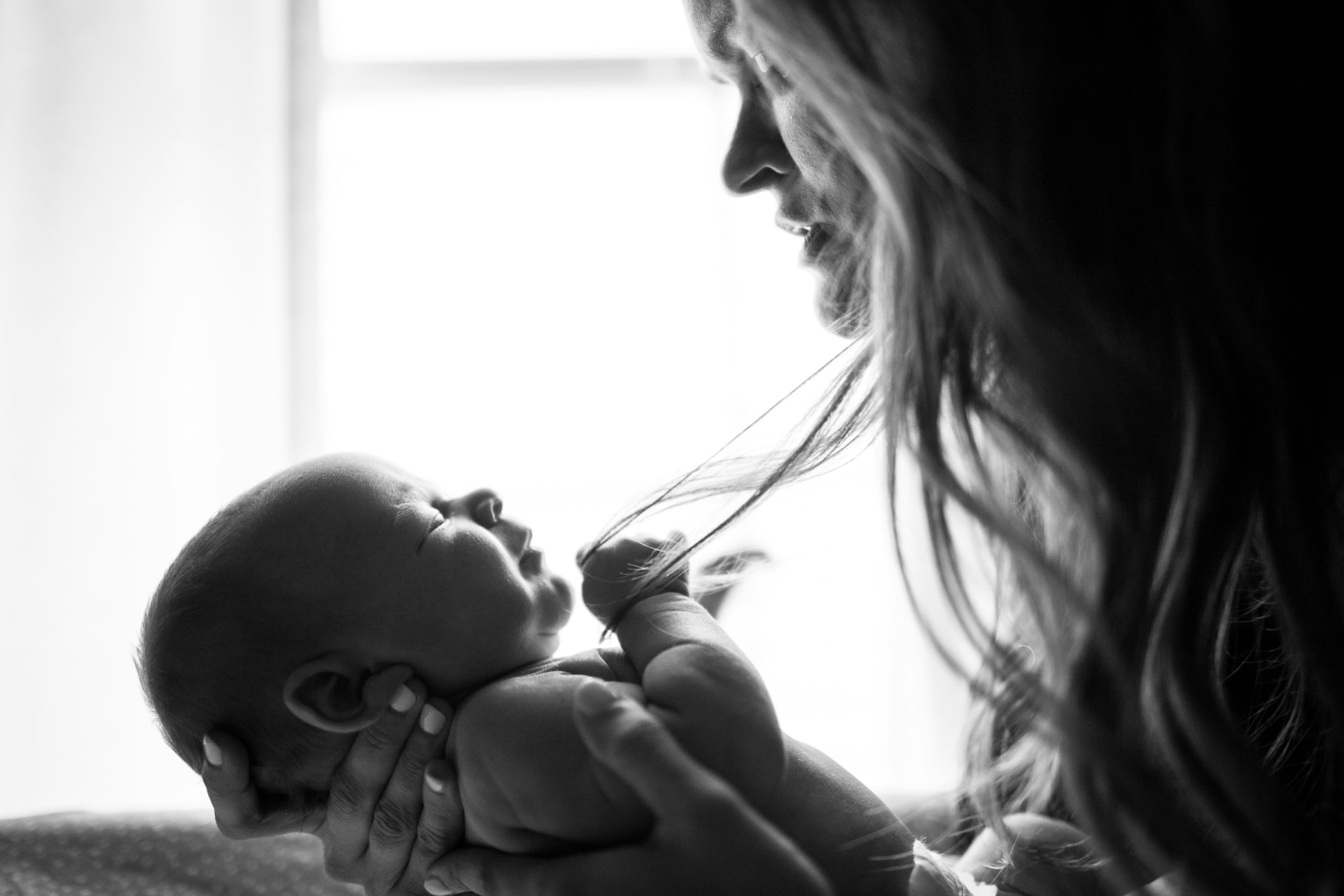 A mother cradling her newborn in black and white