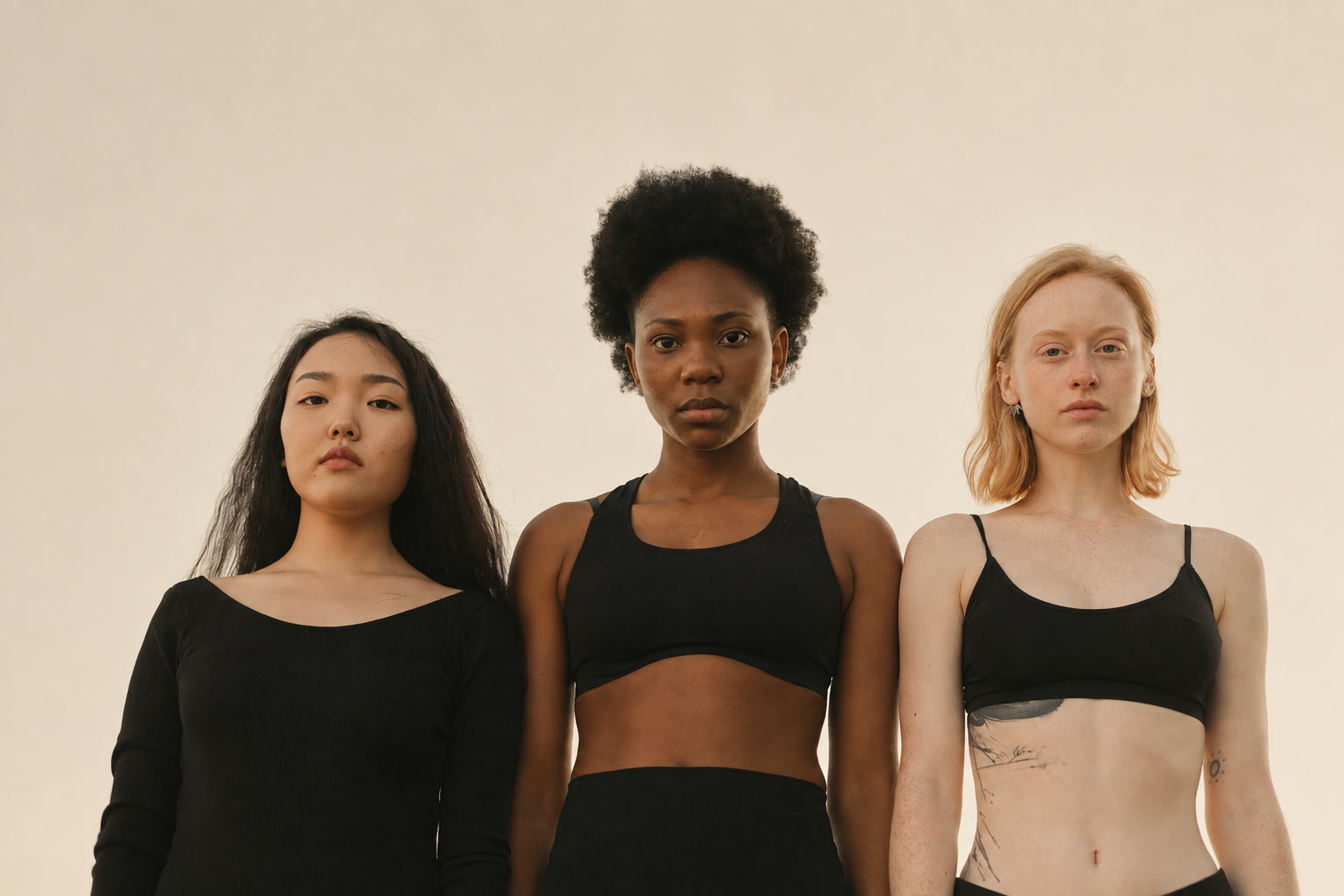 Five women of different body types standing arm in arm, seen from behind